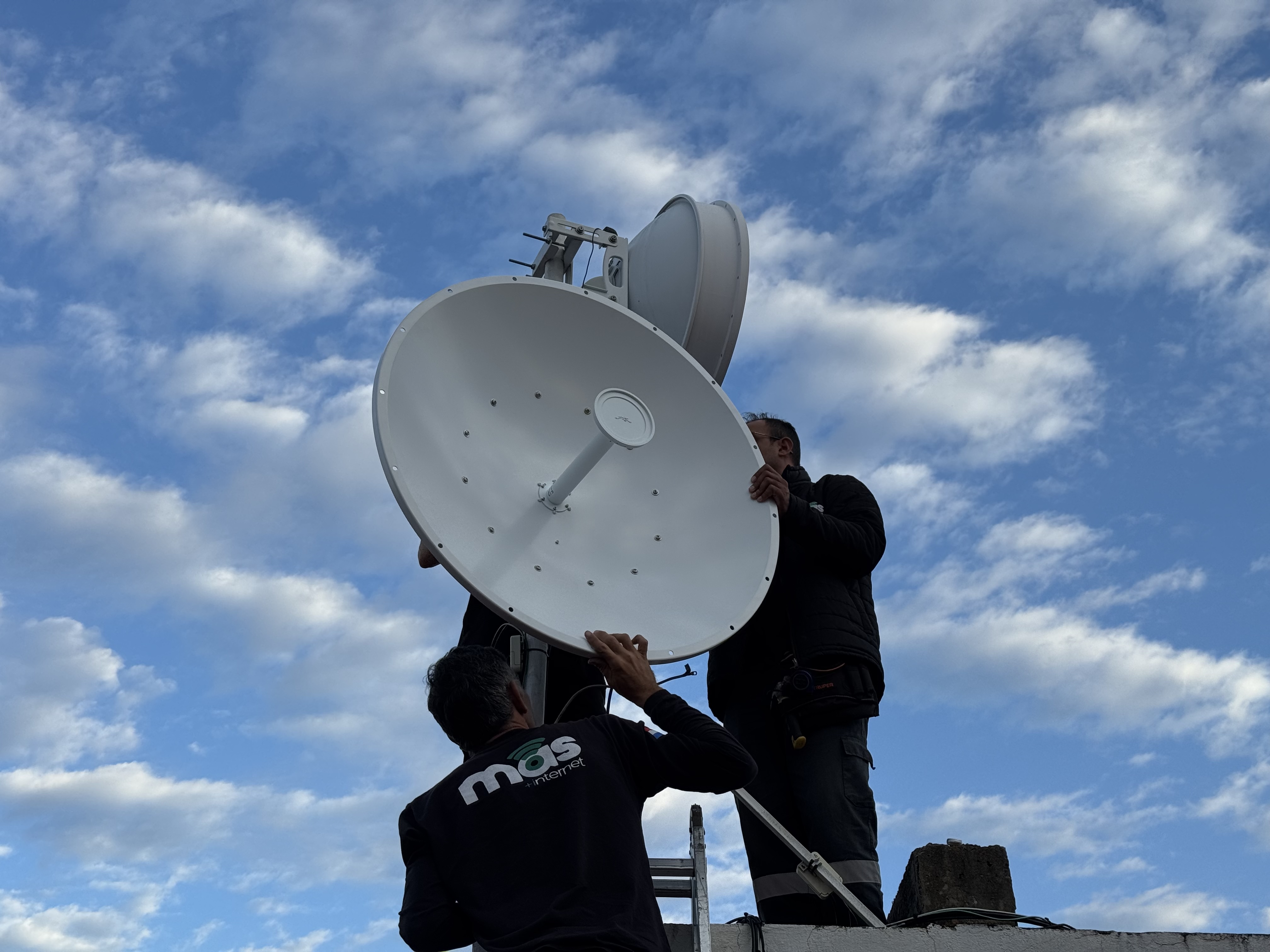 Técnicos de MAS Internet instalando antena de conexión inalámbrica